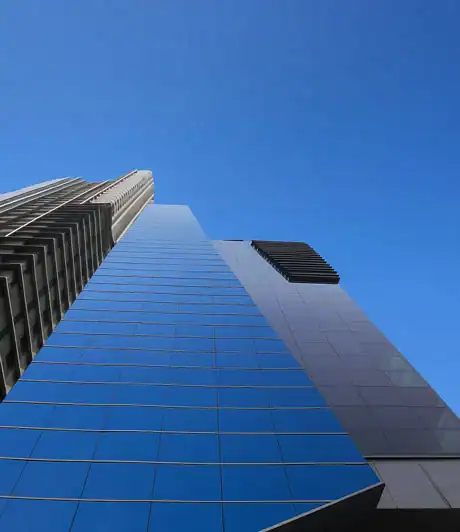 Modern high-rise building with reflective blue glass facade.